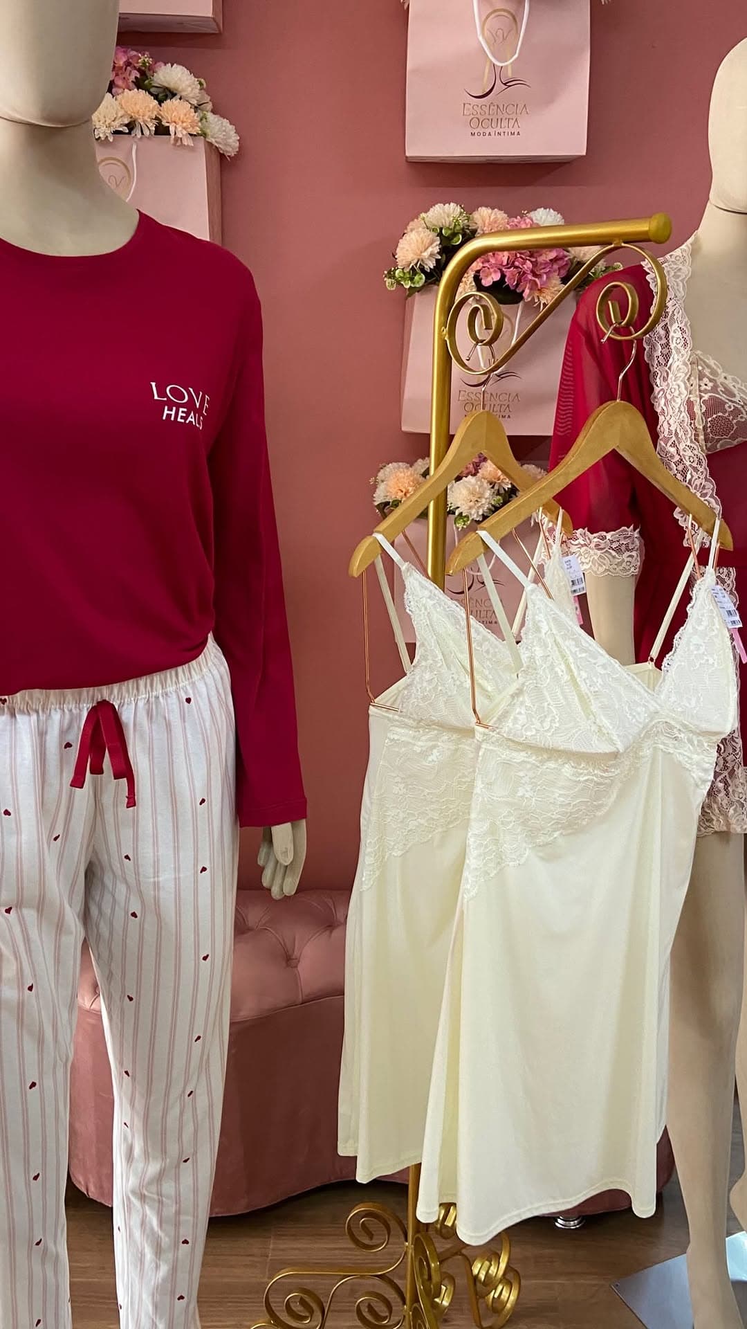 Arara dourada com camisolas off-white em renda e pijama vermelho na vitrine da semana