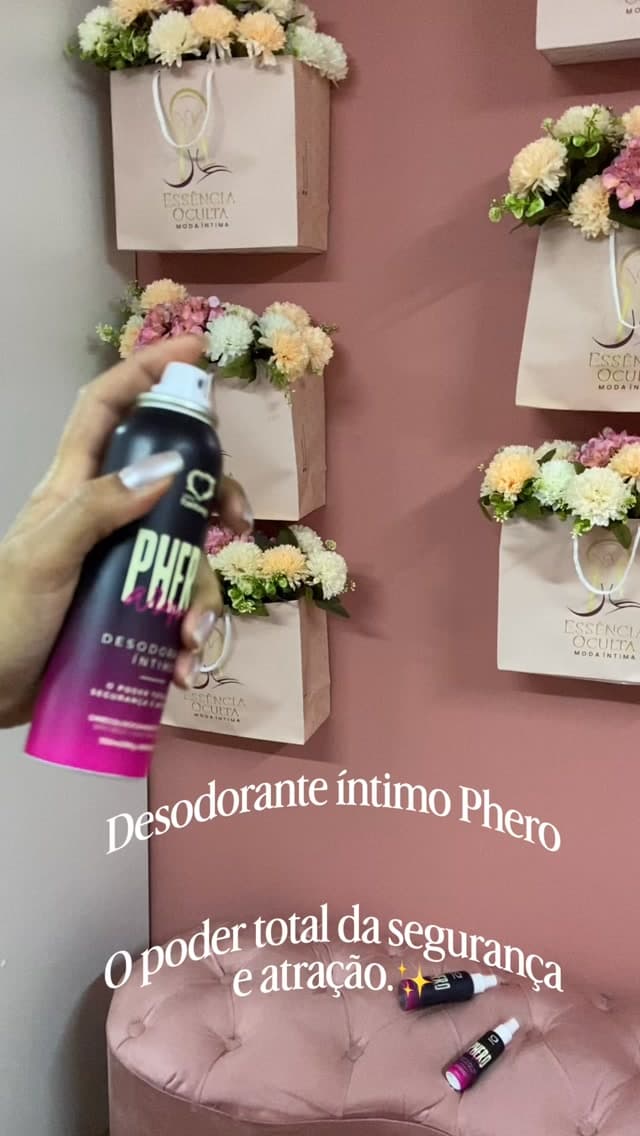 Produtos da linha Phero em frente à parede rosa com sacolas da boutique
